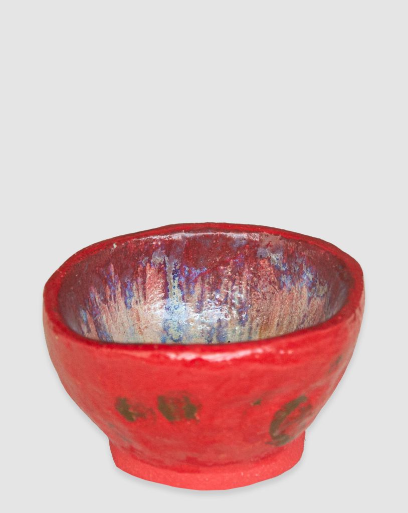 Discover the Kattu Coccinella Ceramic Bowl, featuring a red exterior with a burn effect, blue ripple inside, and a natural burning glaze. Australian-made ceramic bowl with a red exterior and burn effect, featuring a blue ripple design inside on a white background with a natural burning glaze.