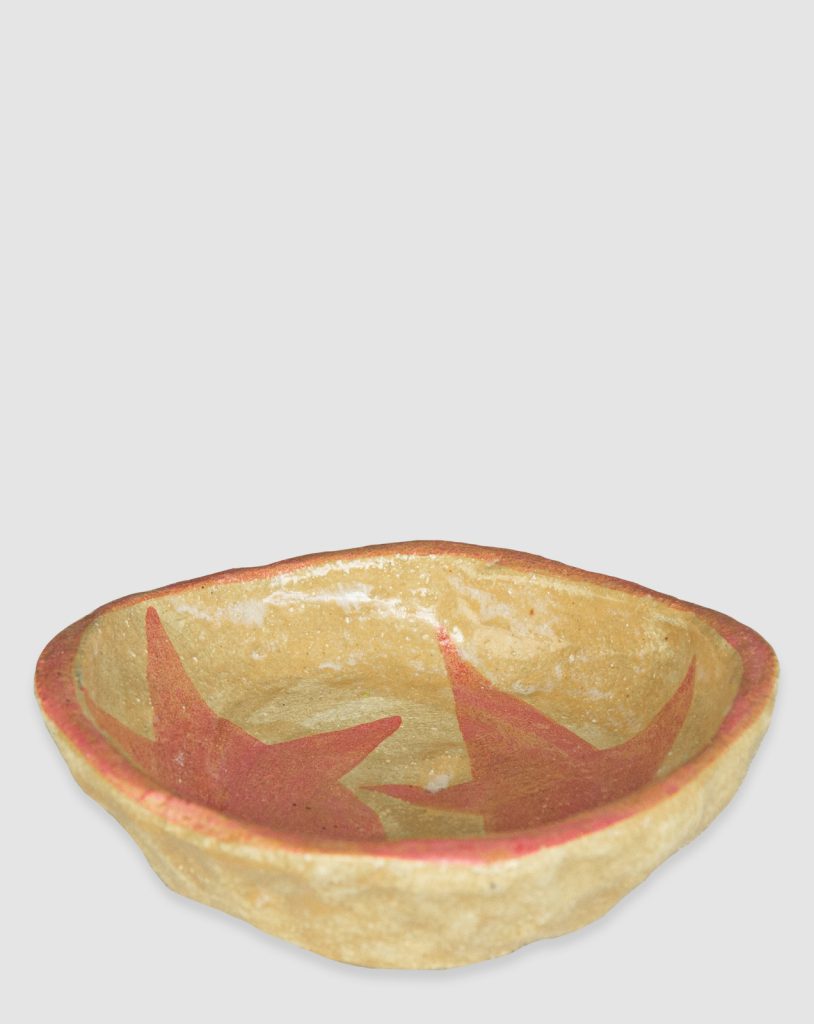 Australian-made ceramic bowl with a natural burnt glaze background and hand-painted pink stars connected in an artistic design.