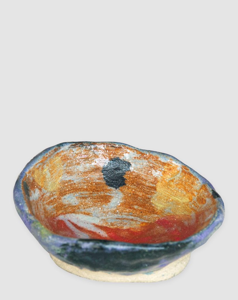 Discover the Kattu Daub Ceramic Bowl, featuring a blue exterior with colour splatters, red painted interior, and a natural burning glaze. Handcrafted in Australia, perfect for trinkets, jewellery, or as a decorative accent.