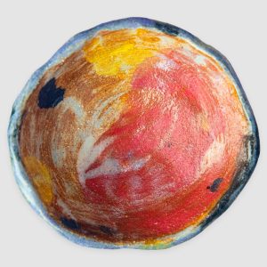 Discover the Kattu Daub Ceramic Bowl, featuring a blue exterior with colour splatters, red painted interior, and a natural burning glaze. Handcrafted in Australia, perfect for trinkets, jewellery, or as a decorative accent.